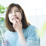 骨隆起を気にする女性のイメージ｜歯茎に白いコブのようなものはできていませんか？｜港南台の歯医者 港南台パーク歯科クリニック