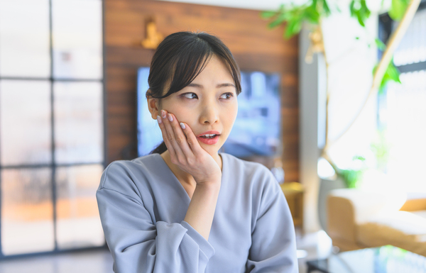 抜けた歯を気にする女性の写真|歯が抜けた状態、放置しても大丈夫?|港南台の歯医者 港南台パーク歯科クリニック